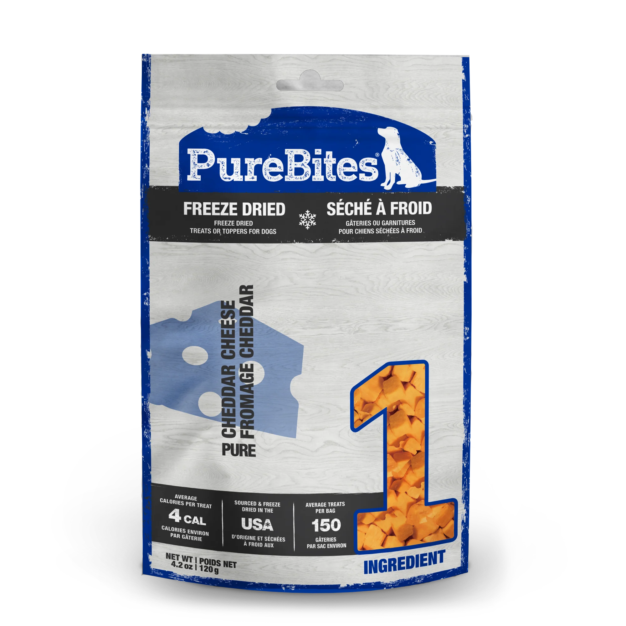 Front view of a bag of PureBites Freeze Dried Cheddar Cheese Dog Treats. The packaging is predominantly white and blue with a rustic wood design, showing chunks of orange cheddar cheese forming a large number "1." Key features include "Freeze Dried," "Cheddar Cheese," "Made in the USA," and "Only 1 Ingredient." The bag highlights low-calorie treats (4 calories per piece) and approximately 150 treats per 120g bag.